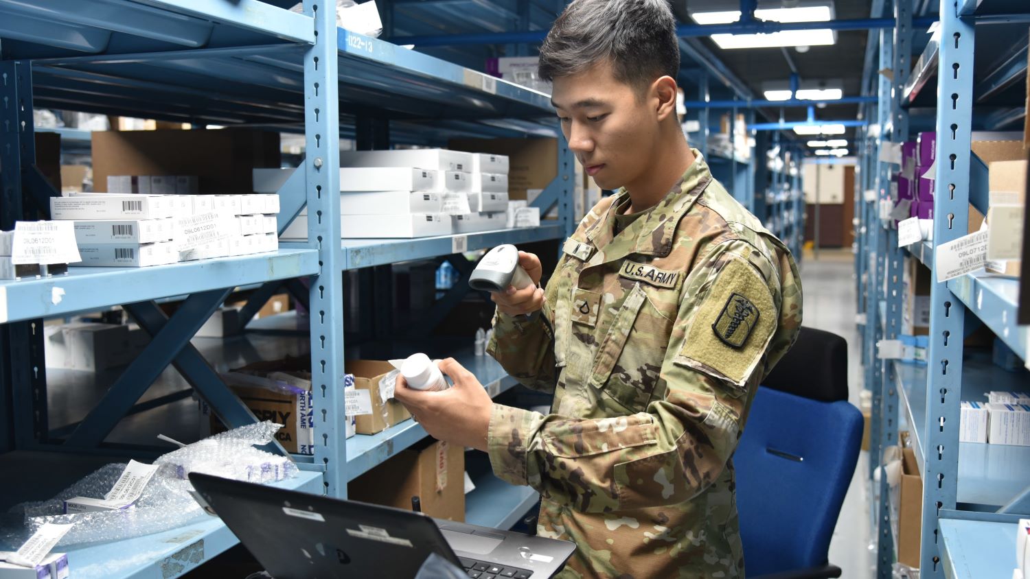 Staff member scans medication at a warehouse or storage facility