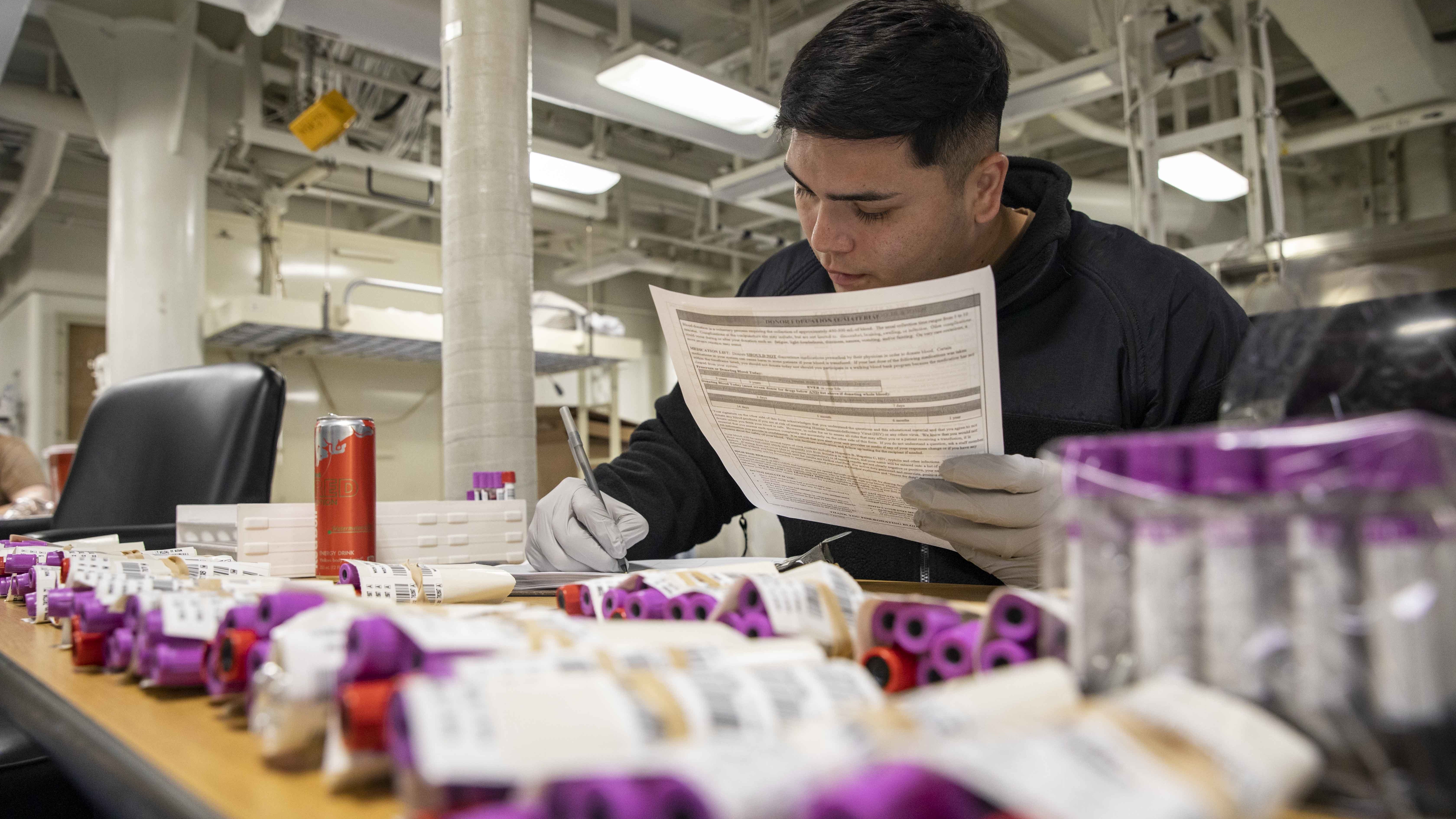 technician cataloging vials of donated blood
