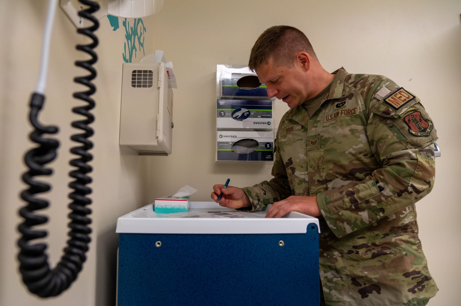 Soldier fills out medical paperwork in exam room