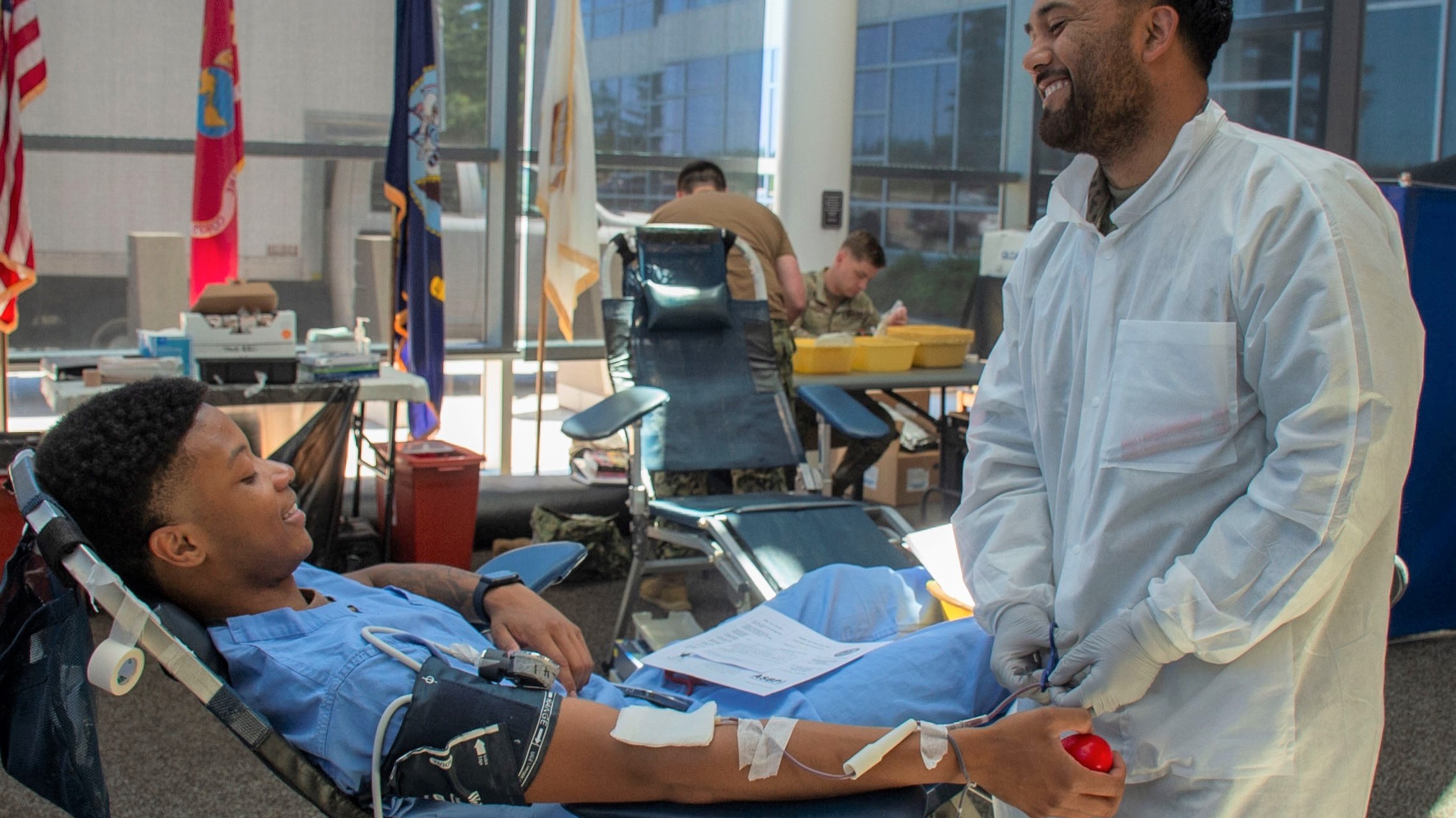 Medical professionals chat while one gives blood