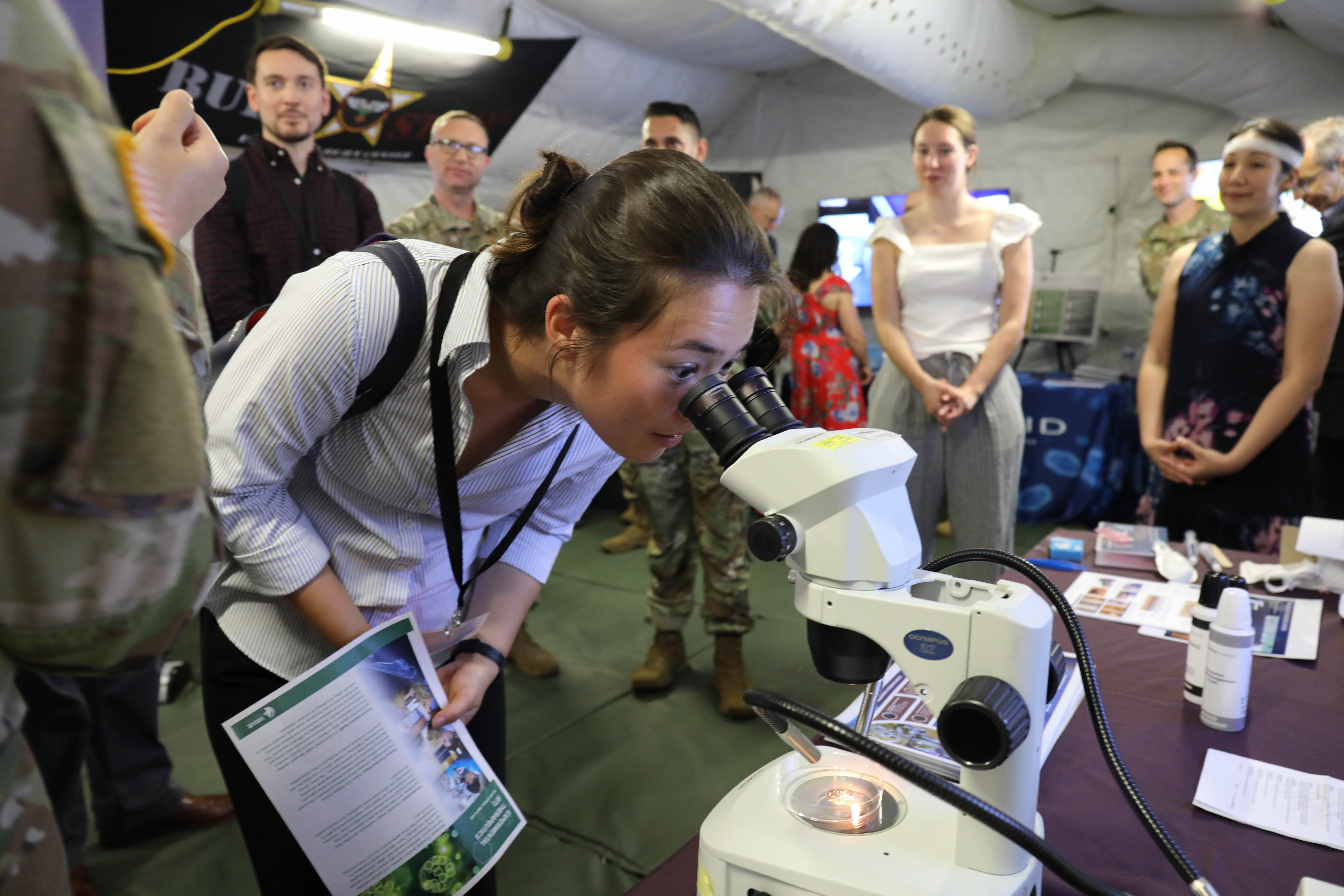 Student looks into microscope at conference