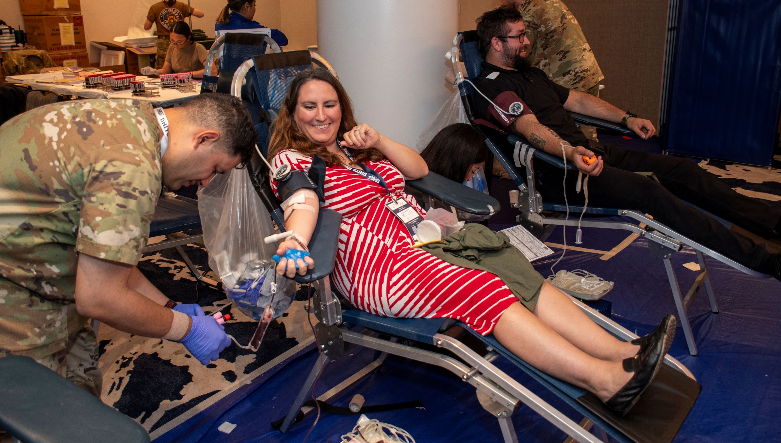 woman gives blood to nurse in uniform