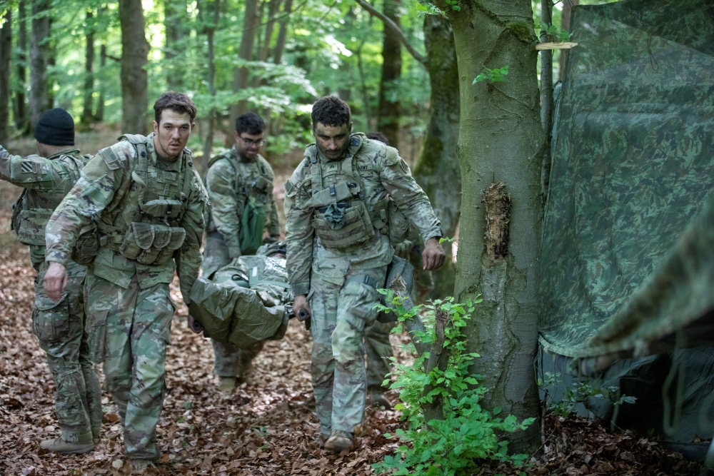 Soldiers with the 1st Battalion, 41st Field Artillery Regiment, 3rd Infantry Division, carry a simulated casualty on a litter to a medical trauma tent 