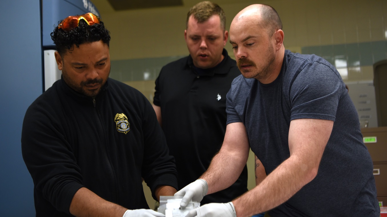 Mr. Carlos Colon, left, U.S. Army Sgt. First Class Earnie Williams, center, and U.S. Air Force Maj. Anthony Vinson, right, catalogue remains found during Operation Colony Glacier, June 23, 2023, at Joint Base Elmendorf-Richardson, Alaska. The operation aims at recovering and returning the remains of service members and personal effects from a C-124 aircraft that crash landed in 1952 with 52 souls on board. Staff from the Armed Forces Medical Examiner System have directly participated in these efforts since 2017. (U.S. Air Force photo by Staff Sgt. Deven Schultz)
