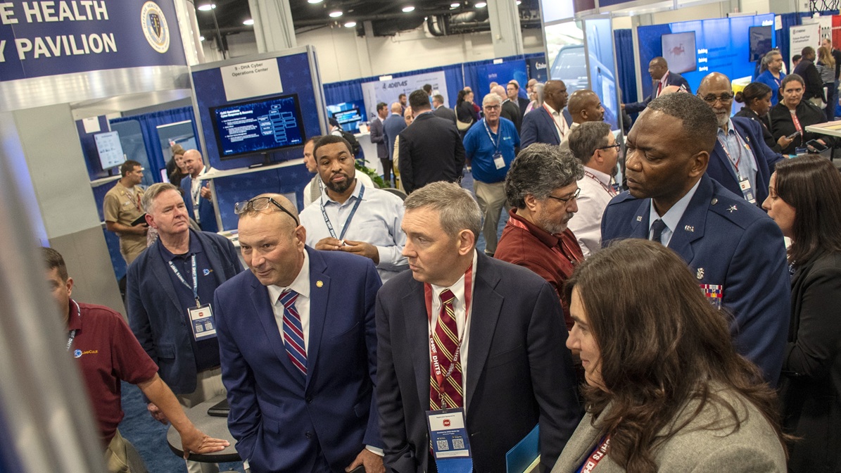 Pat Flanders, chief information officer of the Defense Health Agency, and Dr. Glen Diehl, acting deputy director of Defense Health Agency, take a tour of the exhibition hall at the 2025 Defense Health Information Technology Symposium in Nashville, Tennessee, Aug. 26, 2025. Flanders and Diehl visited the DHA pavilion and spoke with personnel representing different offices from DHA’s headquarters. The symposium focused on the theme, “Empowering Care, Enhancing Readiness: Harnessing Health IT Innovation.”