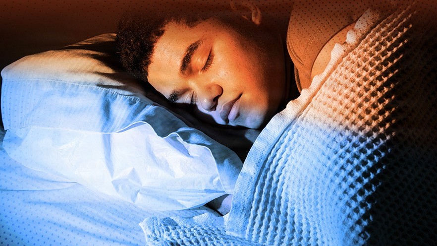 Man sleeping on a pillow with a blanket.