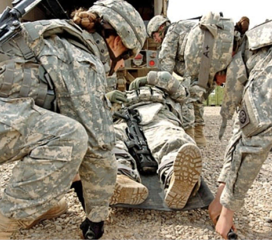 Soldiers picking up an injured soldier on a stretcher