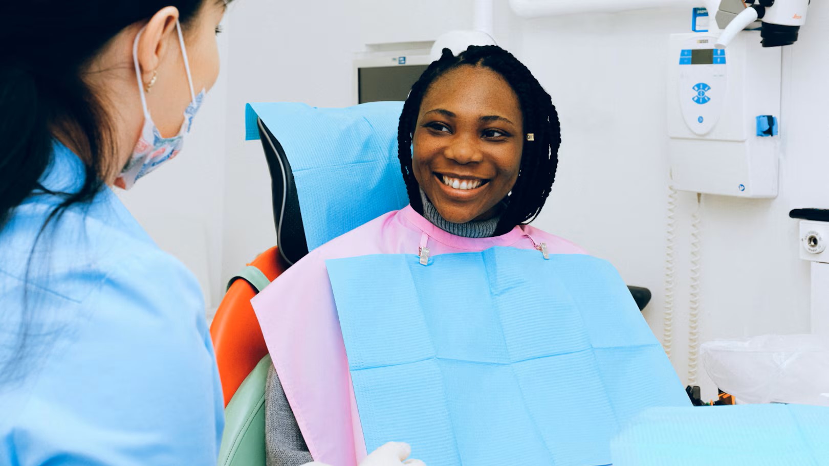 A dentist with a smiling patient in the chair