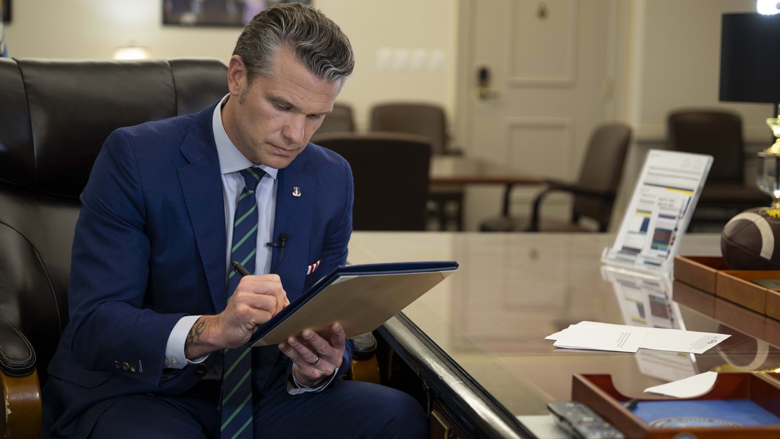 Defense Secretary Pete Hegseth signs a memorandum regarding medical waivers at the Pentagon, April 24, 2025.
