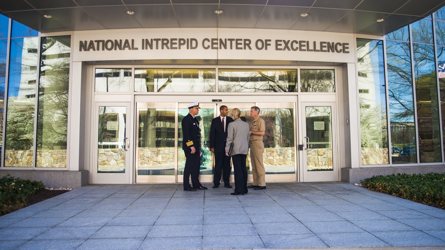 Military personnel standing in front of the National Intrepid Center of Excellence building