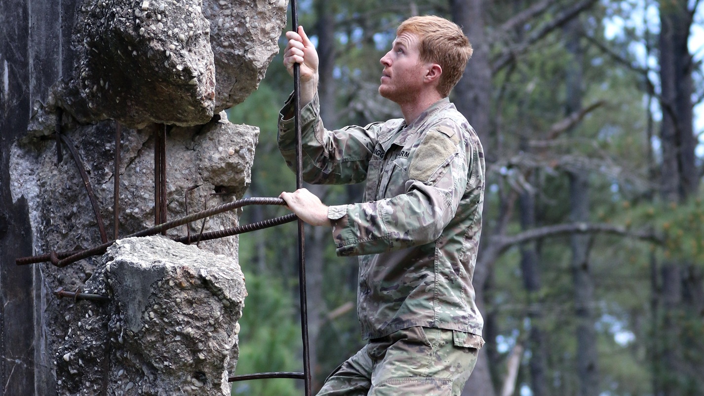 A student assigned to the U.S. Army John F. Kennedy Special Warfare Center and School climbs up an obstacle during the evasion phase of Survival Evasion Resistance and Escape Level-C training (SERE) at Camp Mackall, North Carolina, March 21, 2020. Soldiers in SERE underwent intensive training in support of the Code of the Conduct, and were taught survival fieldcraft skills, techniques of evasion, resistance to exploitation and resolution skills along with critical life saving techniques for austere conditions that are key to survival and the ability to return with honor. (U.S. Army photo by K. Kassens)