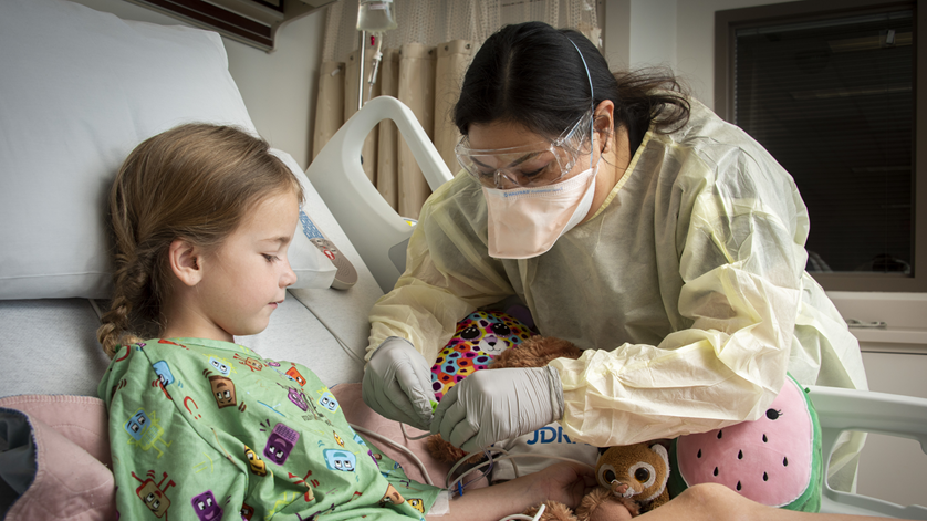 Sheri Flores, Pediatric Intensive Care Unit charge nurse, secures a pulse oximeter on patient, Margaret Moore, at Brooke Army Medical Center, Fort Sam Houston, Texas, March 8, 2022. Moore is the first patient admitted to BAMC’s new Pediatric Intensive Care Unit. (U.S. Army photo by Jason W. Edwards)