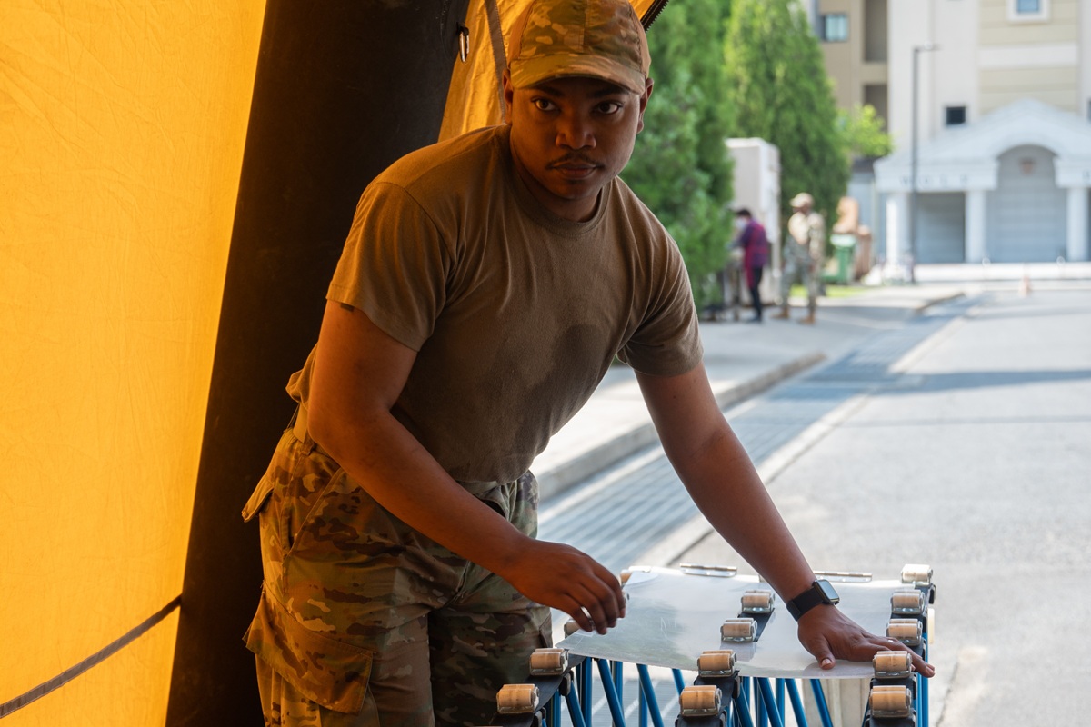 Senior Airman Elijah Yelverton, 8th Operational Medical Readiness Squadron dental assistant, secures a gurney support system during assembly of the In-Place Patient Decontamination Tent at Kunsan Air Base, Republic of Korea, May 15, 2023.