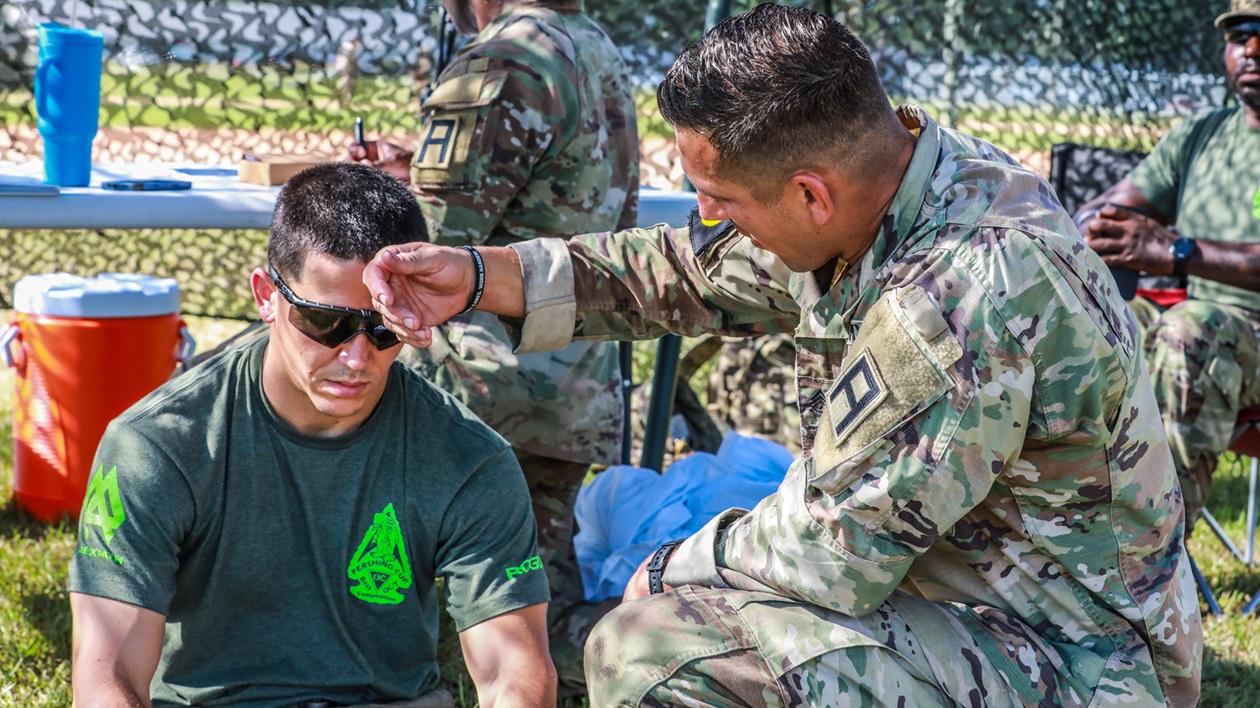 Capt. Jarrod Howell and Sgt. 1st Class Mk-Ada-Quet Generaux, both Observer Coach Trainers with 4th Cavalry Brigade, Division East, First Army out of Fort Knox, Kentucky, treat a simulated heat casualty.