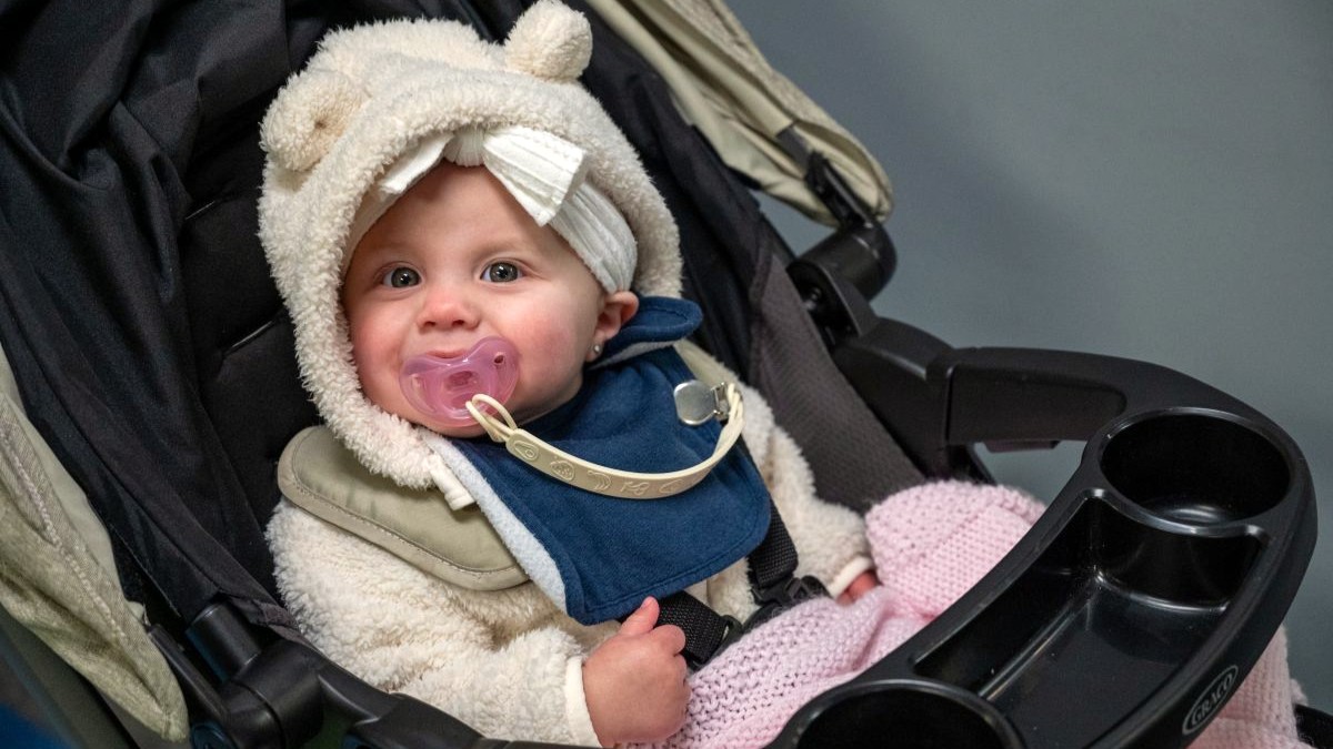A baby smiles inside the Sounder facility after the annual Team McChord holiday tree lighting ceremony at Joint Base Lewis-McChord, Washington, Dec. 5, 2024. The event moved from the ceremony outside to the nearby Sounders facility where children enjoyed arts and crafts, pictures with Santa, and other holiday activities. (U.S. Air Force photo by Airman 1st Class Benjamin Riddle)