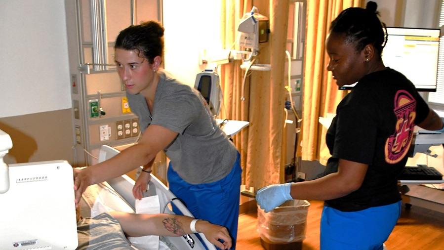 Lt. Memphis Martin (L), a registered nurse and PFC Lore Vil, an LPN check vitals on a patient at Womack Army Medical Center on April 23, 2025.