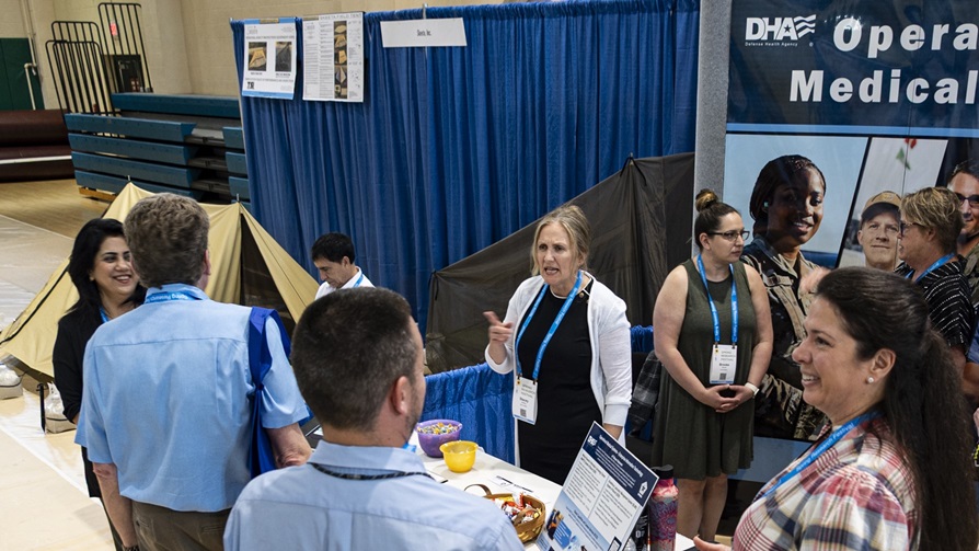 Team members with the Defense Health Agency’s Operational Medical Systems Program Management Office manage an exhibit during the Spring Research Festival Symposium & Exhibition, Fort Detrick, Md., May 1, 2025.