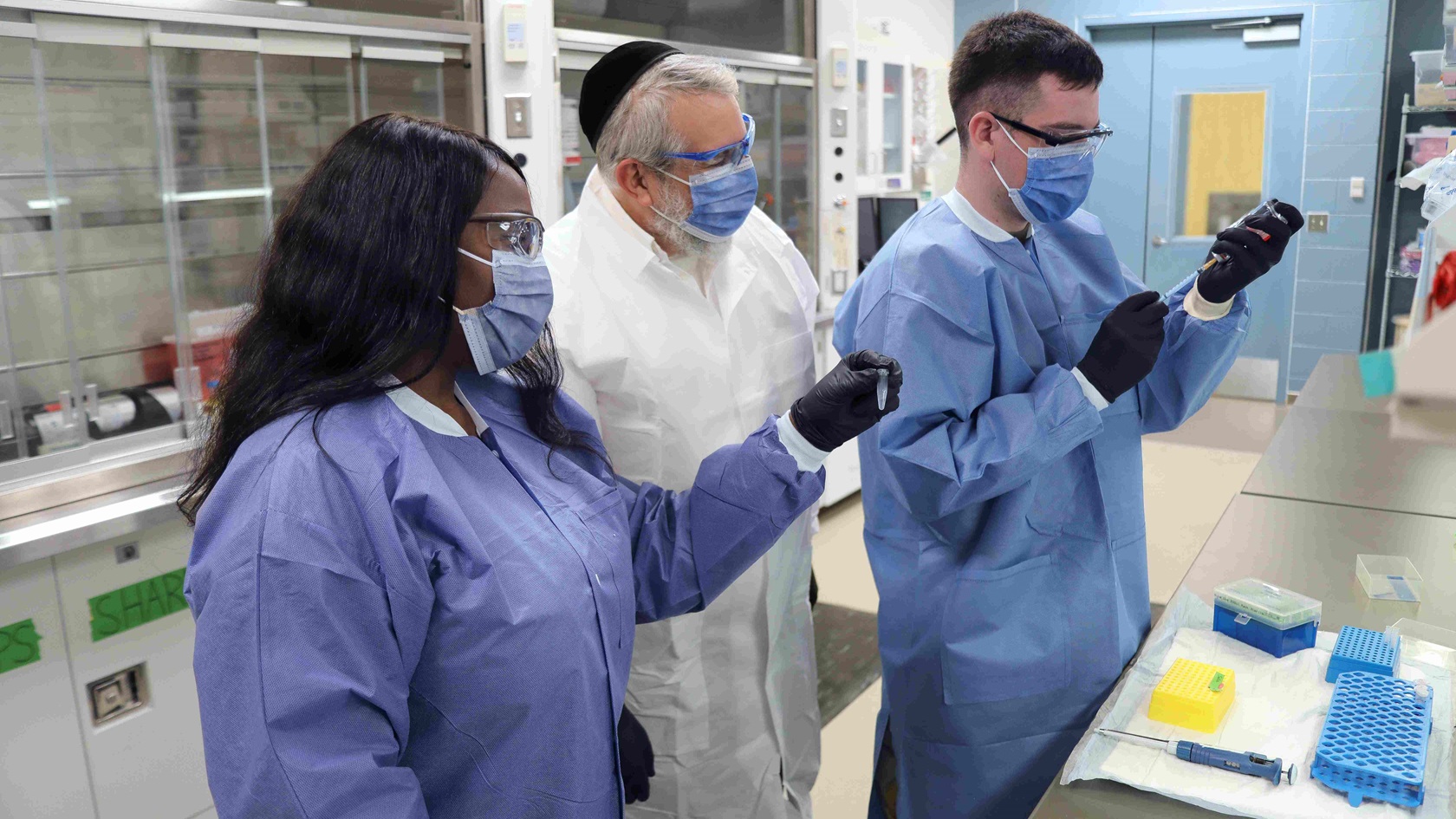 Dr. Gary A. Rockwood, center, a research biologist in the Medical Toxicology Division of the U.S. Army Medical Research Institute of Chemical Defense, observes Laboratory Manager Melissa Rhoomes, left, and Medical Laboratory Specialist Sgt. Cody Raleigh as they prepare laboratory samples for study. 