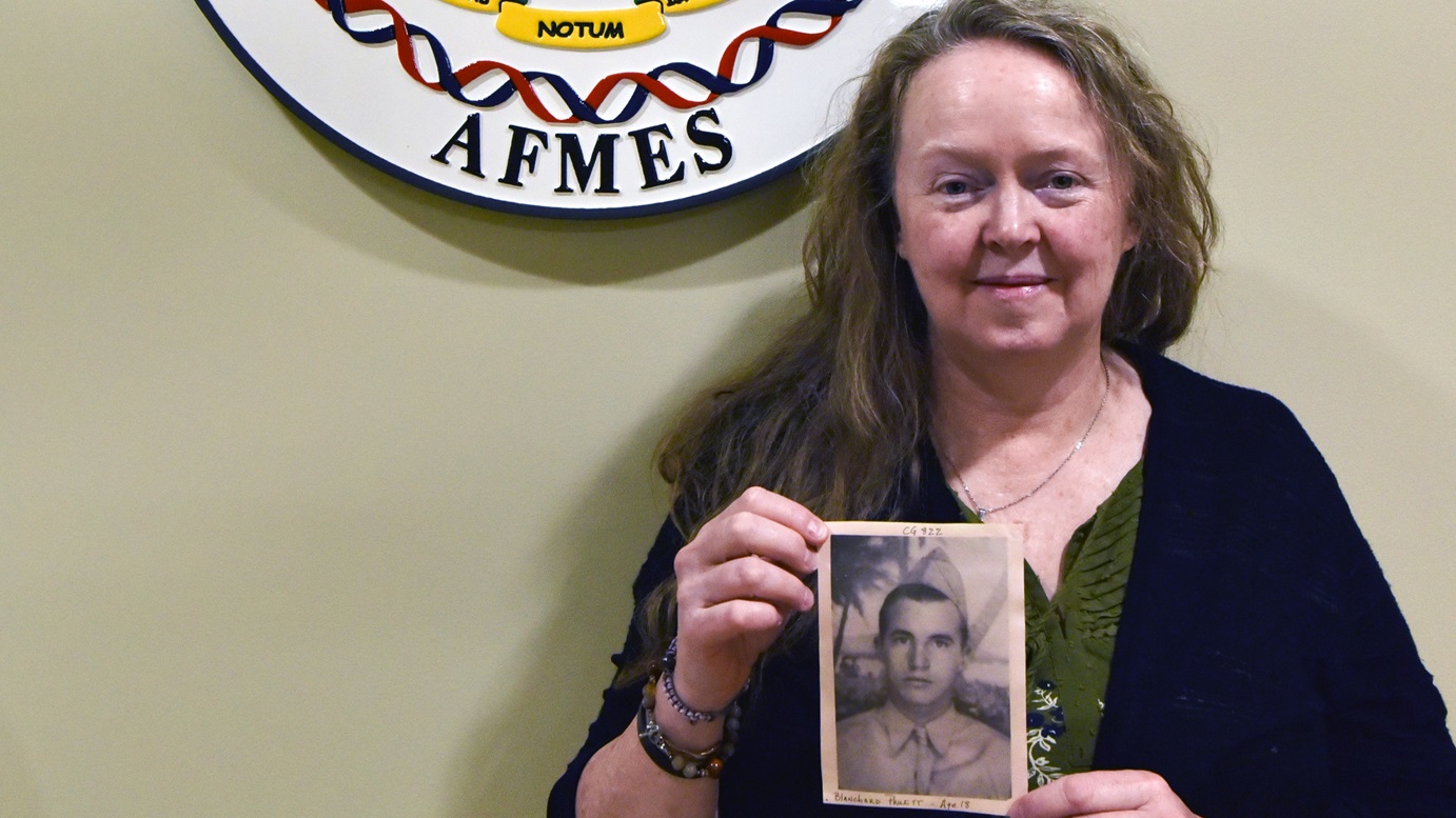 Dr. Suni Edson, Assistant Technical Leader in Past Accounting, Armed Forces DNA Identification Laboratory for the Armed Forces Medical Examiner System, holds a photo of Blanchard Pruitt, her second cousin that was identified from the Cabanatuan POW camp at Dover Air Force base, Delaware