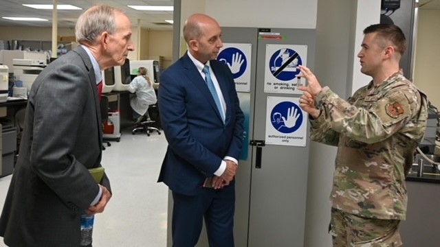Genetics Reference Laboratory Flight Commander Maj. Joel Hughes shows Dr. David Smith, Acting Director, Defense Health Agency, and Dr. Stephen Ferrara, Acting Assistant Secretary of Defense for Health Affairs, a vial containing genetic material during their tour of the Department of Defense’s sole germline clinical genetics laboratory at Keesler Medical Center, Biloxi, Miss.