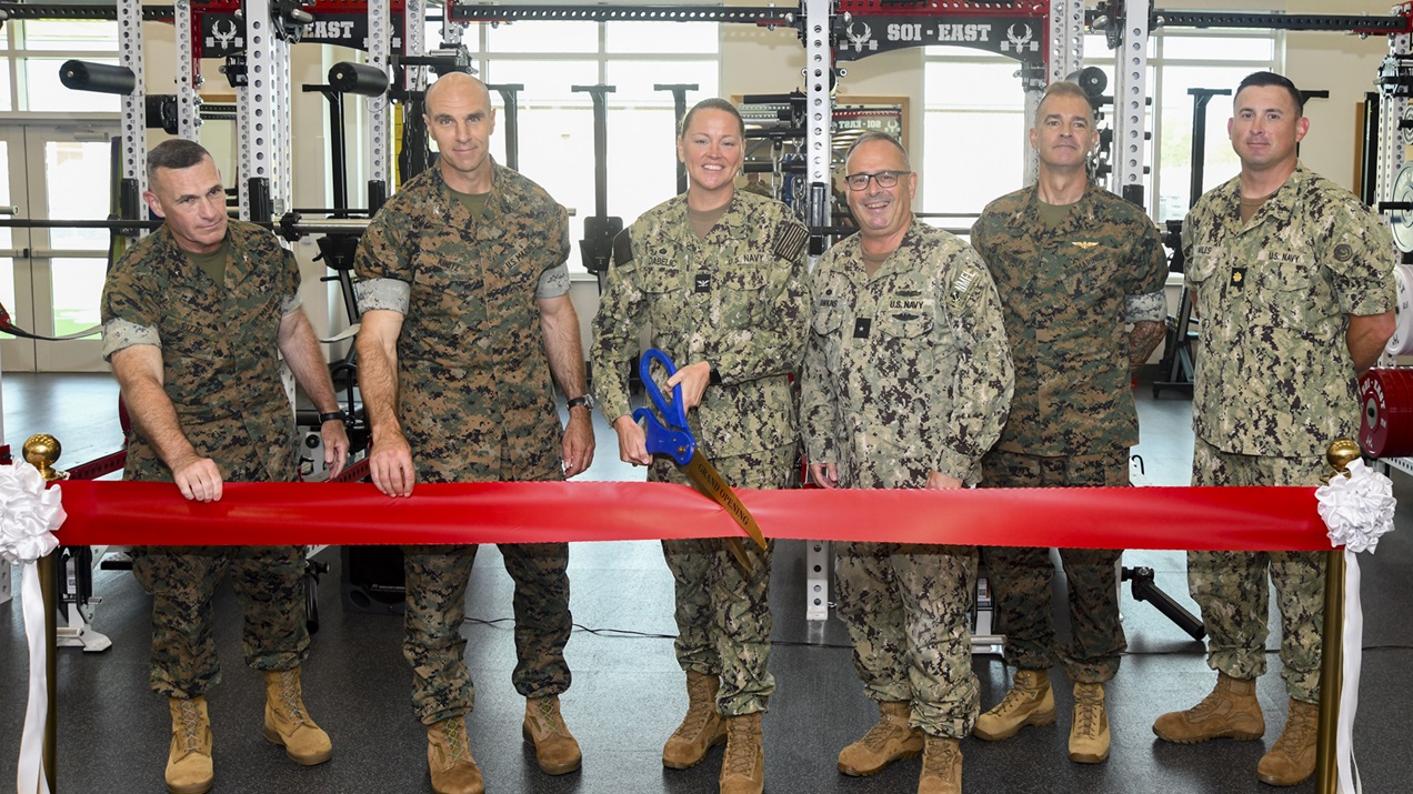  Brigadier General Ralph Rizzo, Commander Aaron Moody, Captain Anja Dabelic, Rear Admiral Robert Hawkins, Colonel Garth Burnett, and Lieutenant Commander Matthew Miles pose for a photo during the Camp Geiger SMART clinic ribbon-cutting ceremony aboard Marine Corps Air Station New River on July 2, 2025. The state-of-the-art Human Performance Center/SMART Clinic integrates sports medicine physicians, athletic trainers, and allied health professionals in a environment focused on returning injured School of Infantry-East students to full mission readiness. (U.S. Navy photo by Mass Communications Specialist second class Justin Woods)