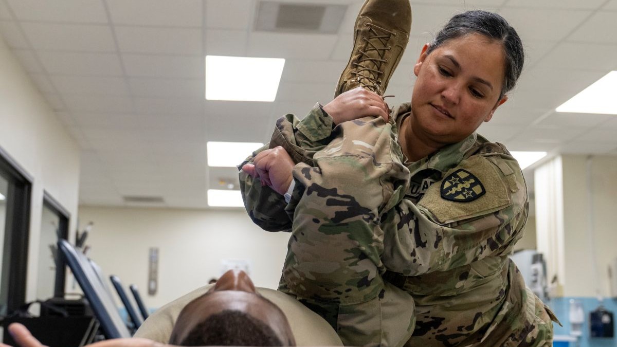 Army Reserve Sgt. Delila Jones, a physical therapy specialist with the Richmond, Va. 7457th Medical Operational Readiness Unit, performs a leg stretch on Sgt. Randy McCartney, a tactical power generation specialist with the 7457th MORU, during Eastern Phoenix 2025 training exercise at the Dwight D. Eisenhower Army Medical Center in Fort Gordon, Ga., Aug. 6, 2025. 39 Soldiers of the 7457th MORU facilitated in teh setup of, and augmented the staffing and support of, the Army Active Component in the annual patient movement and hospital bed expansion exercise. (U.S. Army Reserve photo by Sgt. 1st Class Christopher Hernandez)