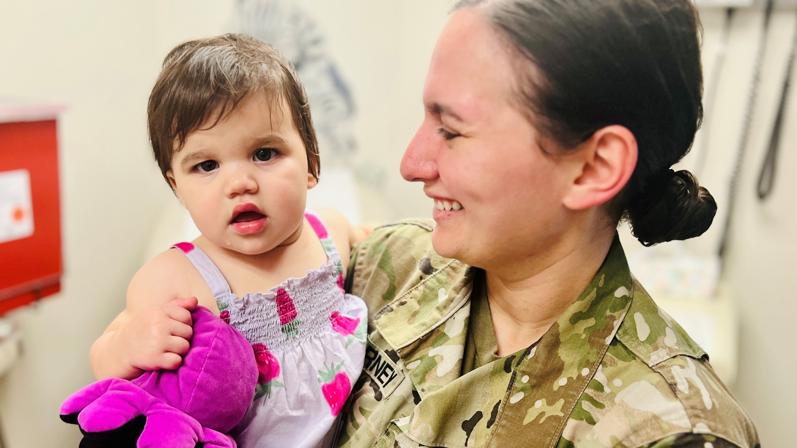 Isabelle, daughter of Capt. Brianna Kearney, chief of public health nursing at Bayne-Jones Army Community Hospital, is held by her mother after receiving routine vaccinations during her one-year well-child checkup at BJACH, Fort Polk, Louisiana