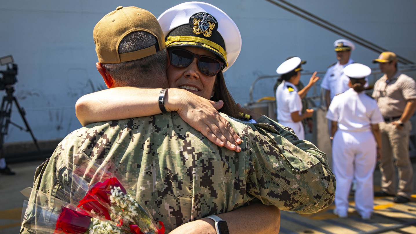 Capt. Katheryn Stewart, the executive officer of the Mercy-class hospital ship USNS Comfort (T-AH 20), hugs Rear Adm. Robert Hawkins, commander, Naval Medical Forces Atlantic (NMFL), and director, Defense Health Network (DHN) - Atlantic after Comfort returns to Naval Station Norfolk, Aug. 17, 2025. 