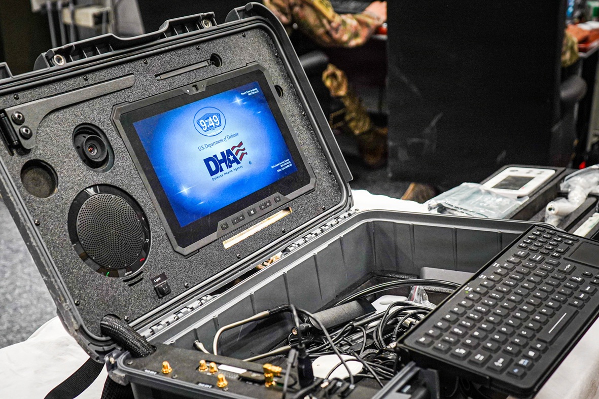 Person with a laptop, with the DHA logo on the screen