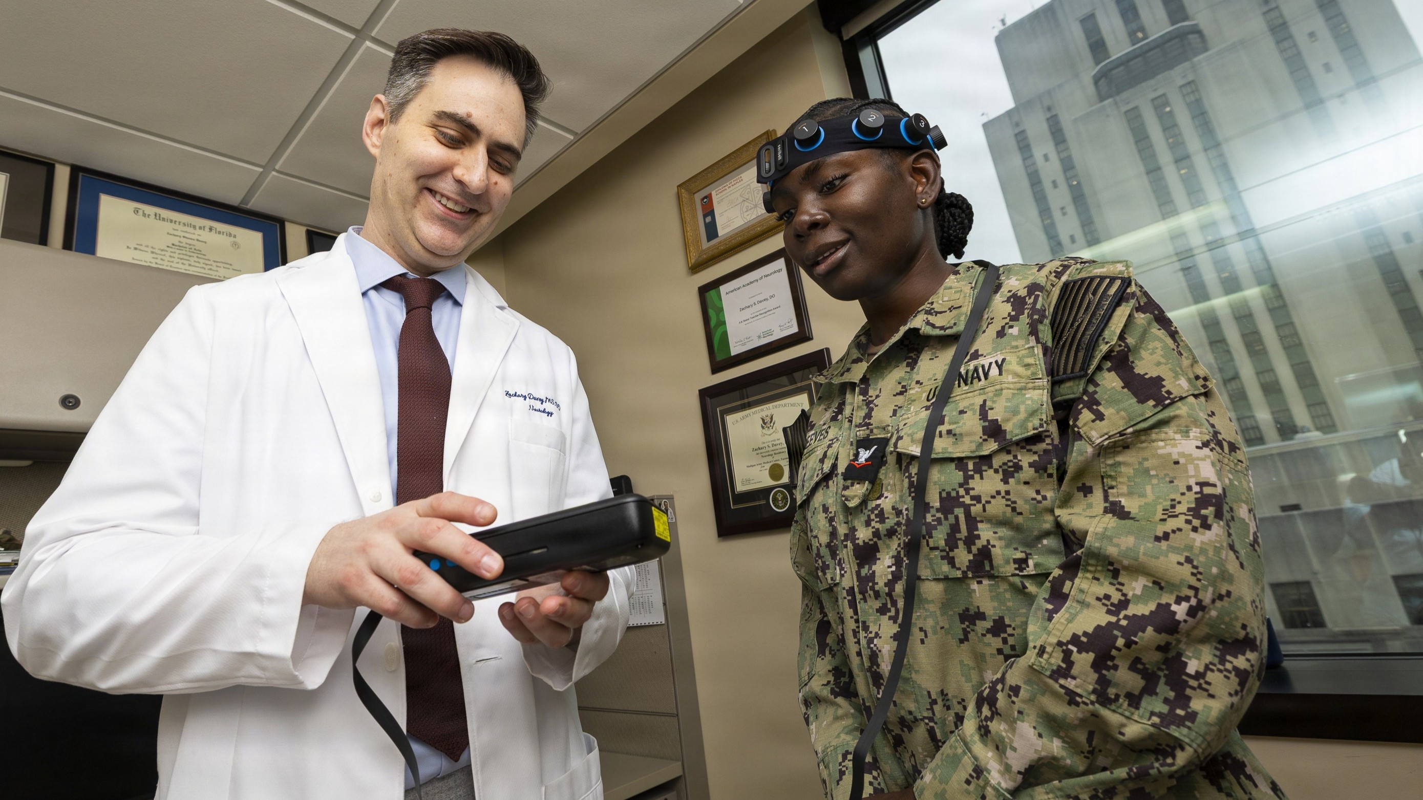 U.S. Army Maj. Zachary S. Davey, a neurologist at Walter Reed National Military Medical Center, reviews data from a point-of-care EEG system with U.S. Navy Hospital Corpsman 3rd Class Tulisa Reeves during a technology demonstration, Bethesda, Md., July 8, 2026. Walter Reed continually evaluates emerging medical technologies to enhance patient care and expand access to advanced diagnostics for the service members, veterans, retirees and military families it serves. (DOW photo by Ricardo J. Reyes)