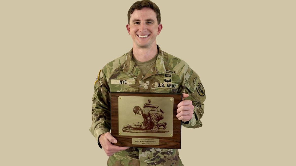 U.S. Army Maj. Dr. Kennedy Nye holds the plaque he recently earned as the Military Health System Research Symposium's 2026 Young Investigator for his team’s research into controlling bleeding at or near the point of injury.