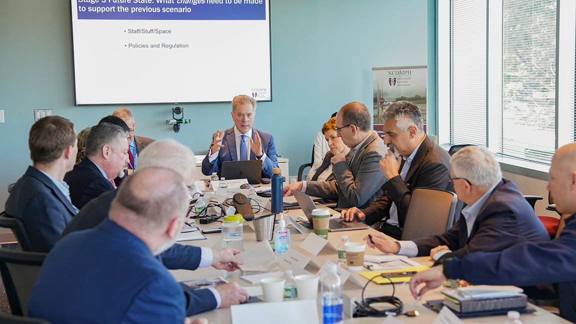 Dr. Michael Anderson, co-chair of the Council of Chief Medical Officers, talks to CCMO meeting attendees about the challenges of delivering timely and effective medical care in high-intensity combat situations. (Photo by David Arthur, HJF)