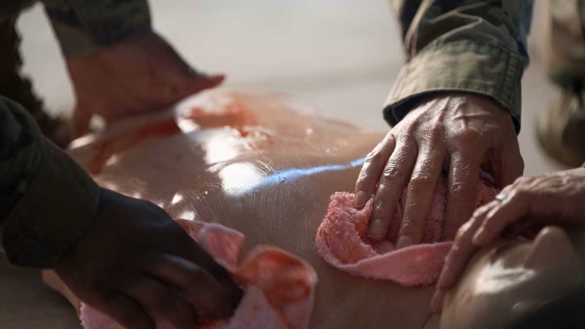 Medics from the 49th Medical Group wash blood from a simulated casualty during a Medic-X exercise at Holloman Air Force Base, N.M., July 16, 2025. Post-mortem protocols and procedures are just a small part of the skills that medics are unable to practice regularly in a clinic, but the Medic-X training exercise gives them a platform to shake the dust off these kinds of practical applications. (U.S. Air Force photo by Tech. Sgt. Victor J. Caputo)