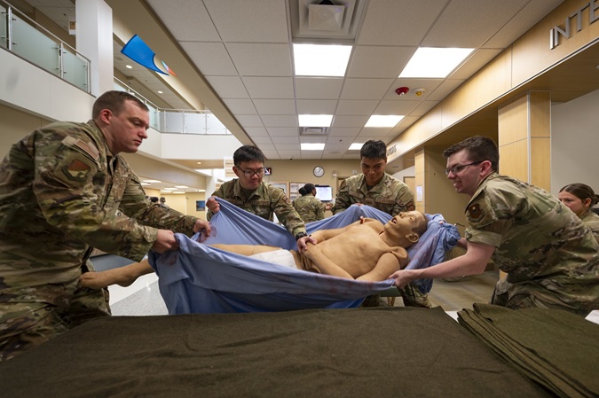 Airmen from the 49th Medical Group transfer a 200-pound training dummy from a gurney to an operating table during a Medic-X exercise at Holloman Air Force Base, N.M., July 16, 2025. This exercise allowed every member of the medical group to sharpen field skills they are not able to practice every day while providing critical clinical support to Team Holloman. (U.S. Air Force photo by Tech. Sgt. Victor J. Caputo)