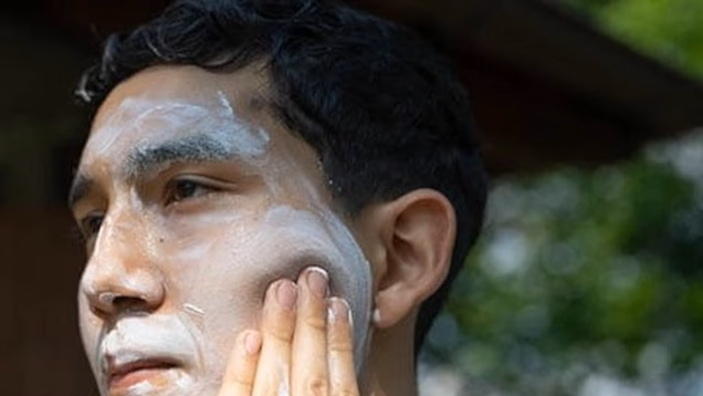 Man putting sunscreen on his face