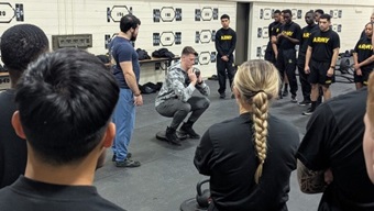 Sgt. John Dumetz, a noncommissioned officer with 2nd Battalion, 87th Infantry Regiment, 2nd Brigade Combat Team, demonstrates the proper movement for a goblet squat to a group of Soldiers.