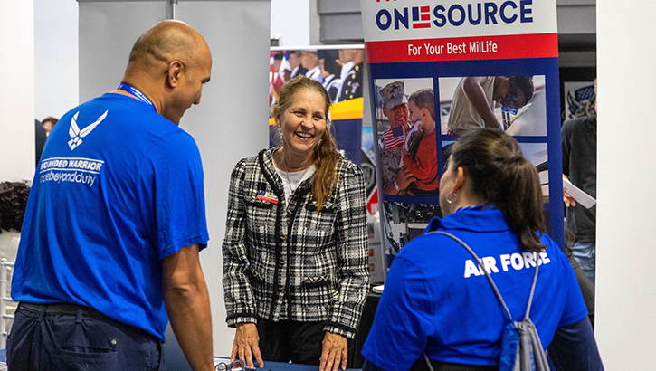 A recovering Airman and caregiver talk with organizations during an Air Force Wounded Warrior CARE Event 