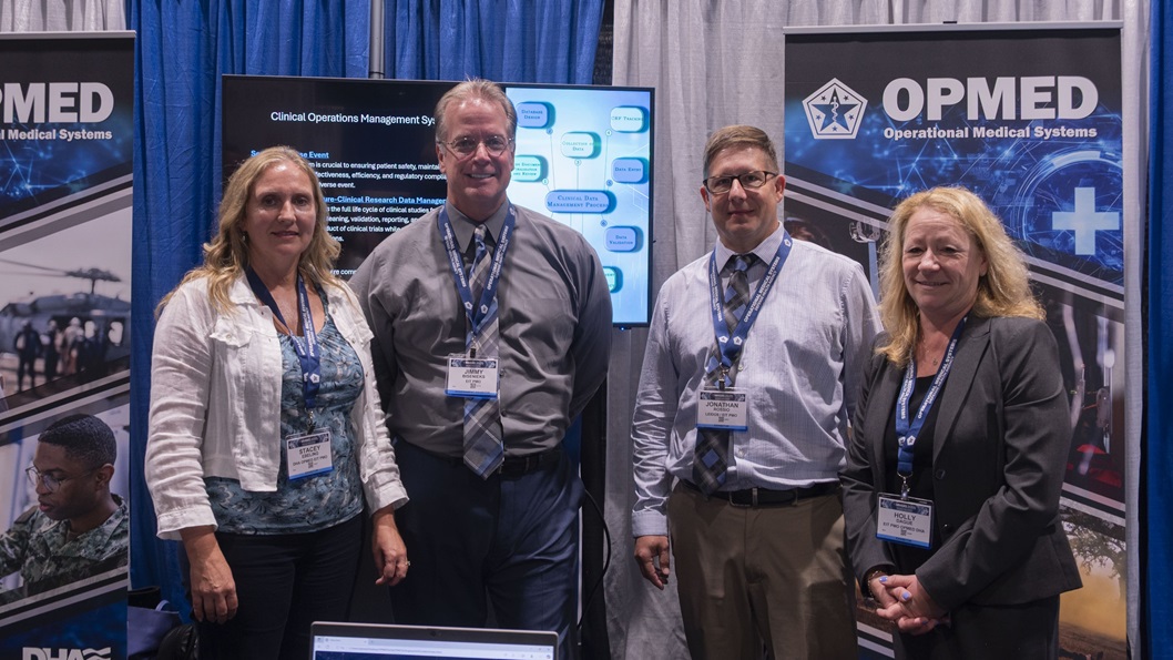 Team members with the Operational Medical Systems Program Management Office stand for a photo during the Military Health System Research Symposium, Kissimmee, Florida, Aug. 4, 2025.
