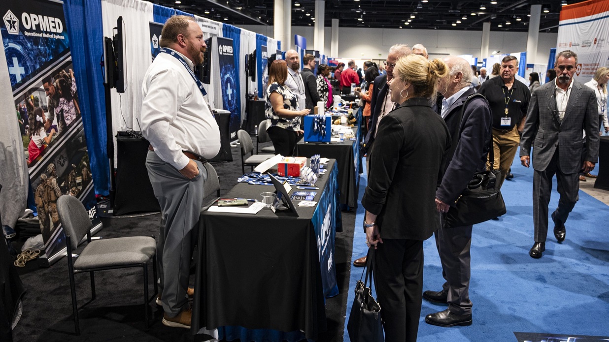 Jon Witt, acting chief of the Office of Research and Technology Applications with the Operational Medical Systems Program Management Office, speaks with attendees of the Military Health System Research Symposium, Kissimmee, Florida, Aug. 5, 2025.