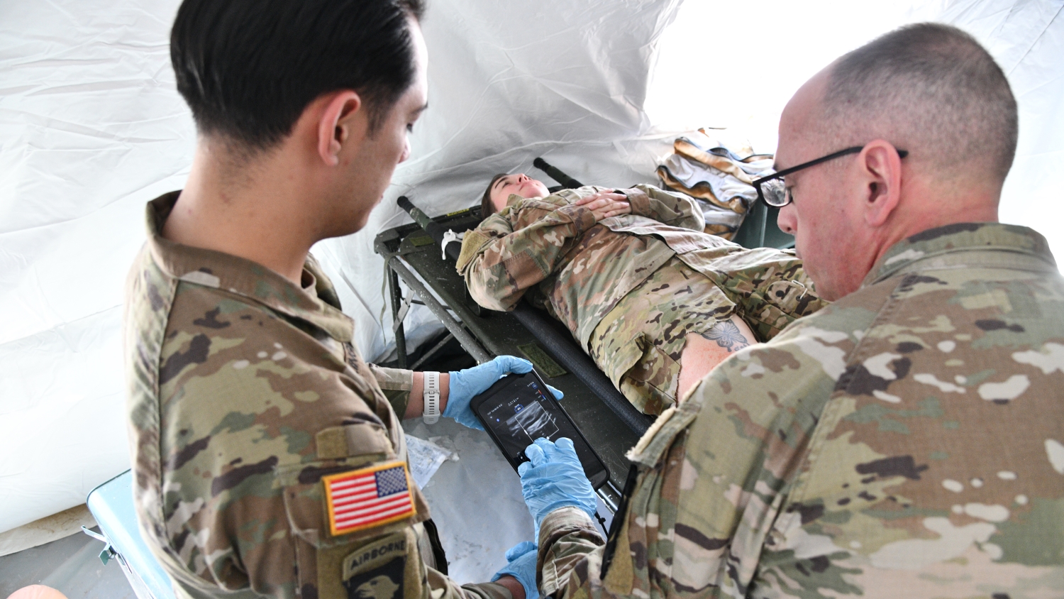 medics look at ultrasound of patient